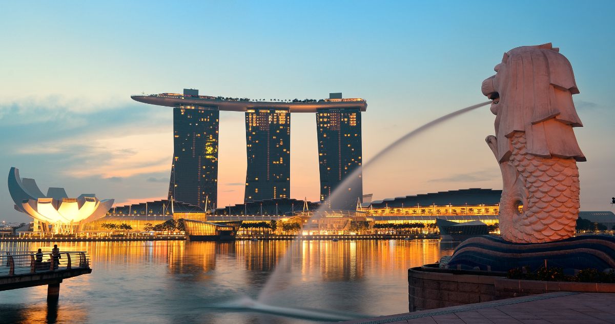 Singapore evening view with Marina Bay Sand at the back and Merlion Statue at the front.